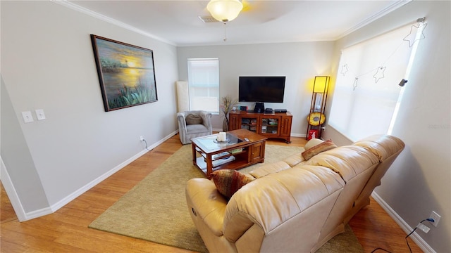 living room with crown molding, ceiling fan, and light hardwood / wood-style floors