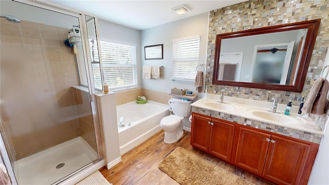 full bathroom with toilet, plus walk in shower, hardwood / wood-style floors, vanity, and backsplash