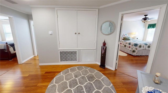 interior space with ornamental molding, a closet, ceiling fan, and light hardwood / wood-style floors