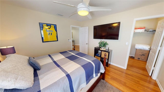 bedroom featuring a closet, a spacious closet, ceiling fan, and light hardwood / wood-style floors