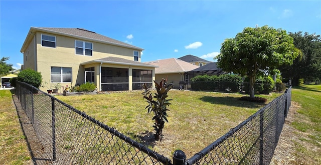 back of property featuring a sunroom and a lawn