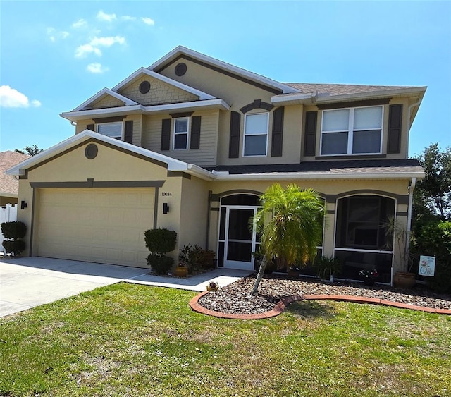 view of front of house with an attached garage, stucco siding, concrete driveway, and a front yard