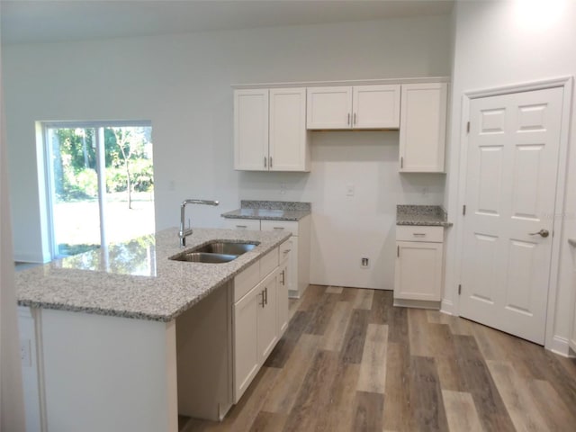 kitchen featuring white cabinets, light stone countertops, sink, and hardwood / wood-style floors