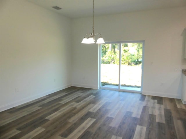 unfurnished dining area featuring dark hardwood / wood-style floors and an inviting chandelier