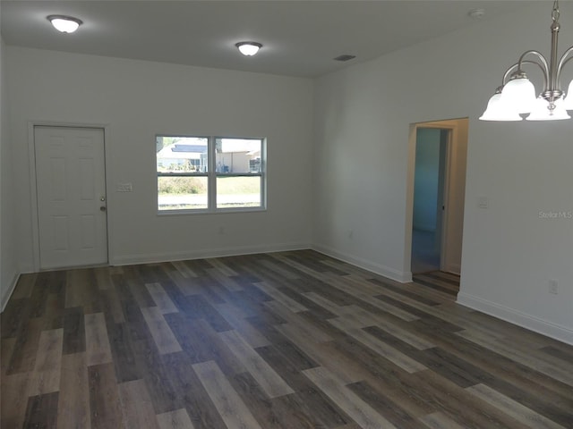 unfurnished room with dark hardwood / wood-style floors and an inviting chandelier