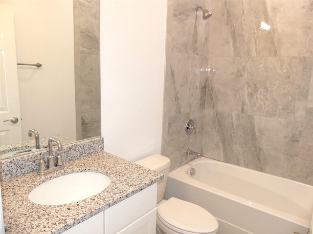 full bathroom featuring vanity, tiled shower / bath combo, and toilet