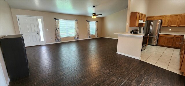 kitchen featuring lofted ceiling, appliances with stainless steel finishes, light wood-type flooring, ceiling fan, and kitchen peninsula