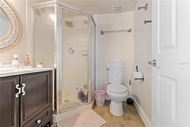 bathroom with vanity, hardwood / wood-style flooring, toilet, and walk in shower