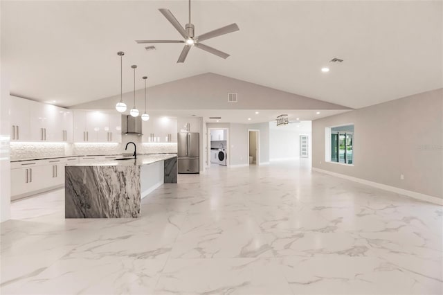 kitchen with a spacious island, sink, high quality fridge, decorative light fixtures, and white cabinetry