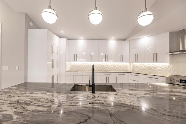 kitchen featuring decorative light fixtures, light stone counters, white cabinetry, and sink