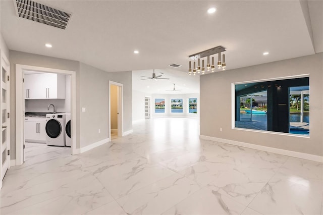 unfurnished living room with ceiling fan and washer and dryer