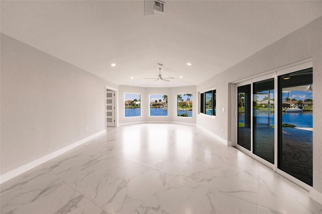 empty room with ceiling fan, a water view, and built in shelves