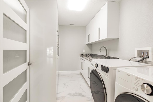 washroom featuring a textured ceiling, cabinets, sink, and washing machine and dryer