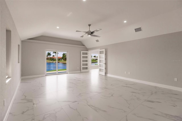 unfurnished room featuring built in shelves, ceiling fan, a water view, and lofted ceiling