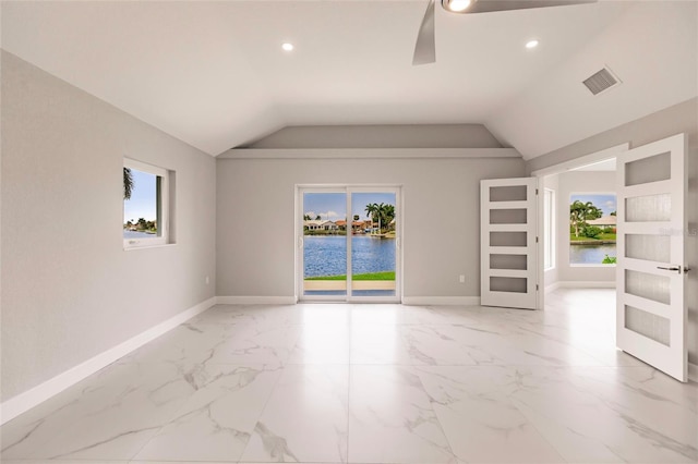 empty room with a water view, ceiling fan, and lofted ceiling