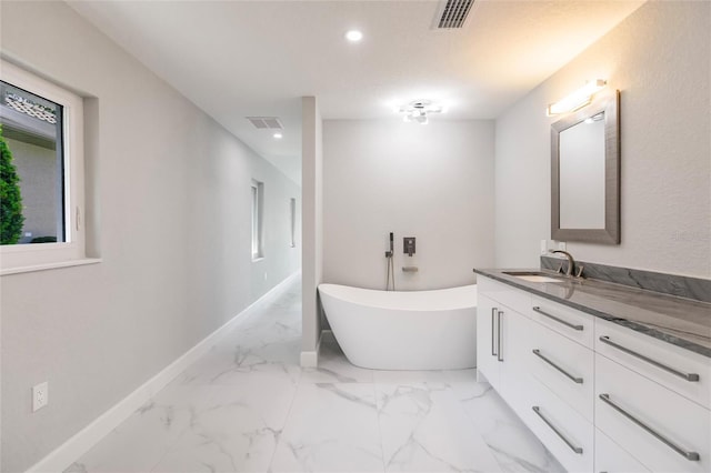 bathroom with vanity and a tub to relax in