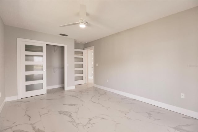 unfurnished bedroom with ceiling fan and a closet