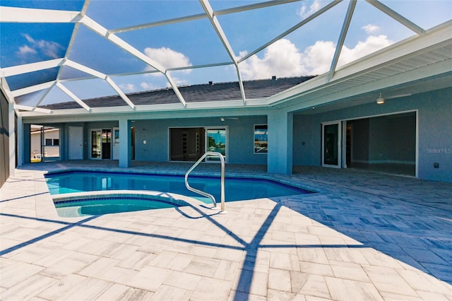 view of swimming pool featuring glass enclosure, a patio area, and an in ground hot tub