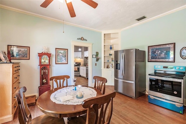 dining space with ornamental molding, built in features, light wood-type flooring, and ceiling fan