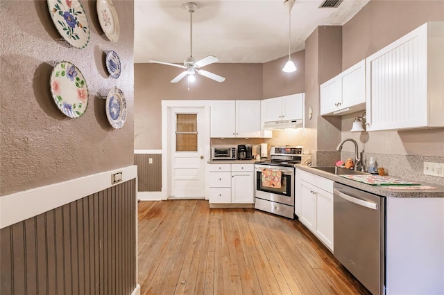 kitchen featuring decorative light fixtures, light hardwood / wood-style flooring, stainless steel appliances, ceiling fan, and white cabinets