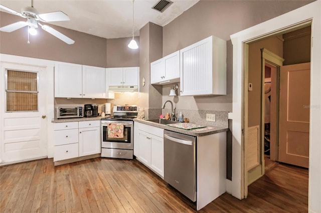 kitchen featuring stainless steel appliances, backsplash, wood-type flooring, sink, and ceiling fan