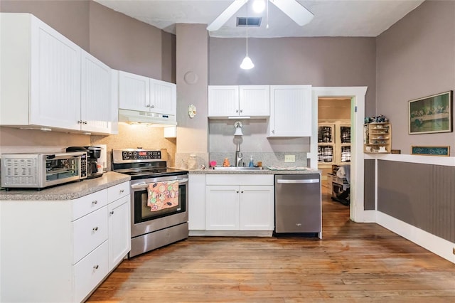 kitchen with ceiling fan, light hardwood / wood-style floors, stainless steel appliances, hanging light fixtures, and white cabinetry