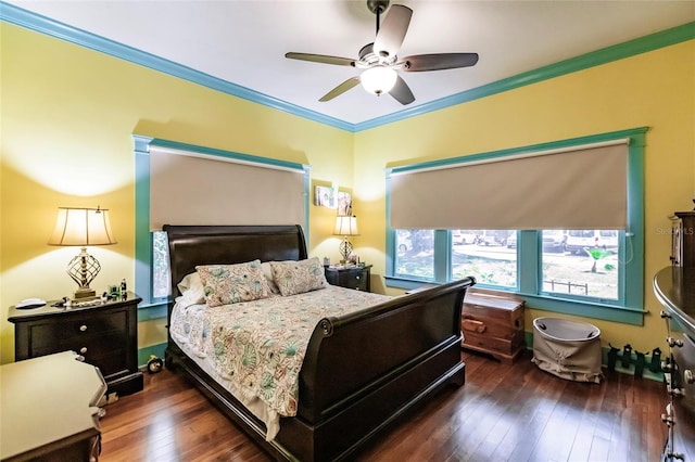 bedroom with dark hardwood / wood-style flooring, ceiling fan, and crown molding