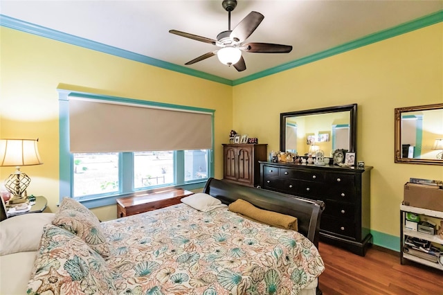 bedroom with crown molding, dark hardwood / wood-style floors, and ceiling fan