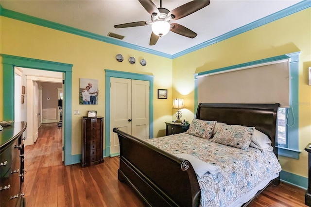 bedroom featuring crown molding, a closet, ceiling fan, and dark hardwood / wood-style flooring