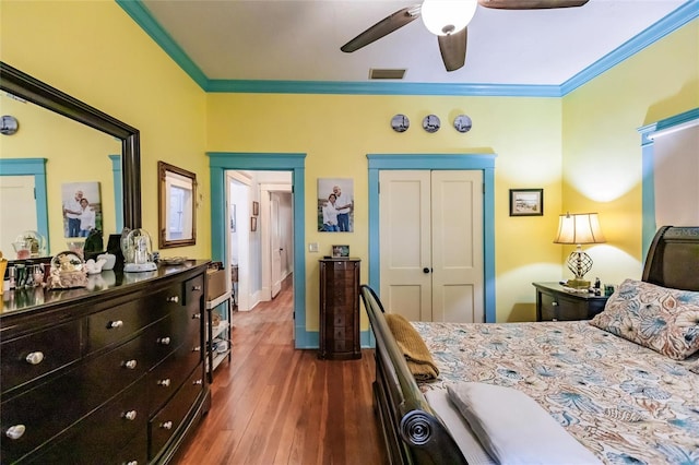 bedroom with a closet, ceiling fan, dark hardwood / wood-style floors, and ornamental molding