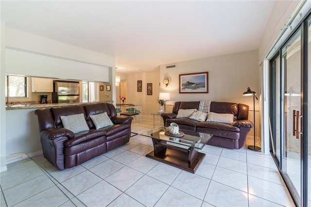 living room featuring light tile patterned flooring and visible vents