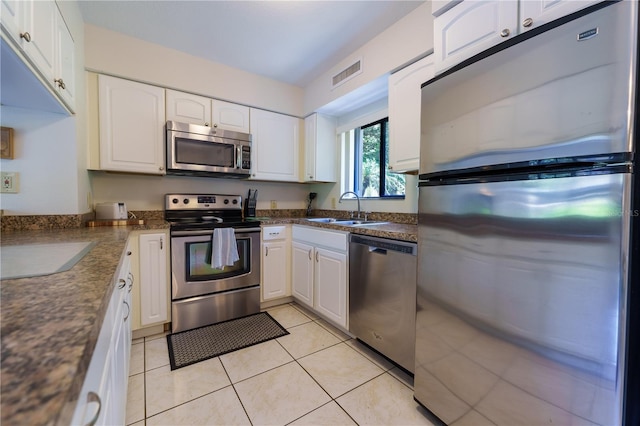 kitchen with white cabinetry, stainless steel appliances, sink, and light tile floors