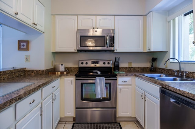 kitchen with white cabinetry, sink, light tile floors, and stainless steel appliances