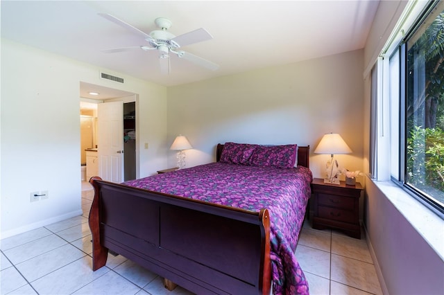 tiled bedroom featuring ceiling fan and ensuite bath