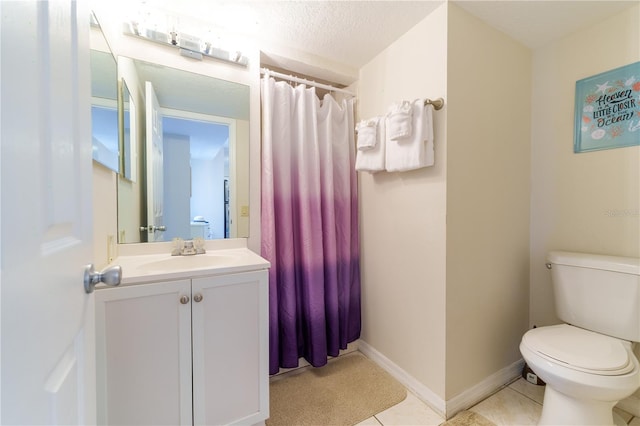 bathroom featuring tile flooring, a textured ceiling, toilet, and large vanity