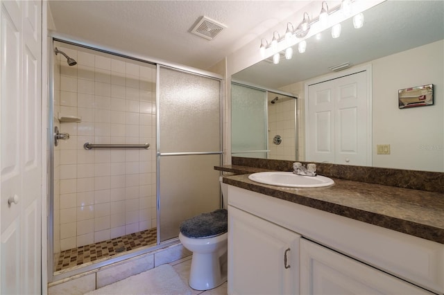 bathroom with walk in shower, a textured ceiling, tile floors, large vanity, and toilet