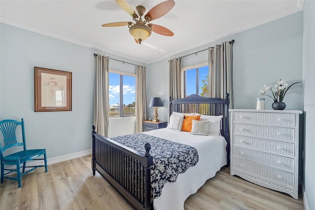 bedroom featuring ceiling fan, light wood-type flooring, and crown molding