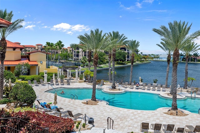 view of swimming pool featuring a water view and a patio area