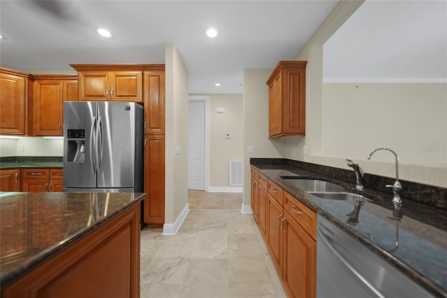 kitchen featuring sink, dark stone countertops, light tile floors, and stainless steel appliances