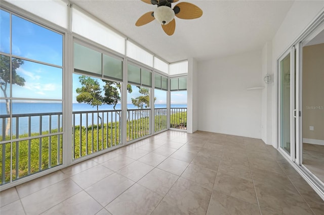 unfurnished sunroom featuring a water view and ceiling fan