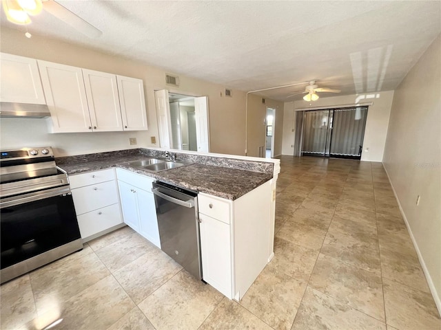 kitchen with wall chimney exhaust hood, white cabinetry, appliances with stainless steel finishes, sink, and ceiling fan