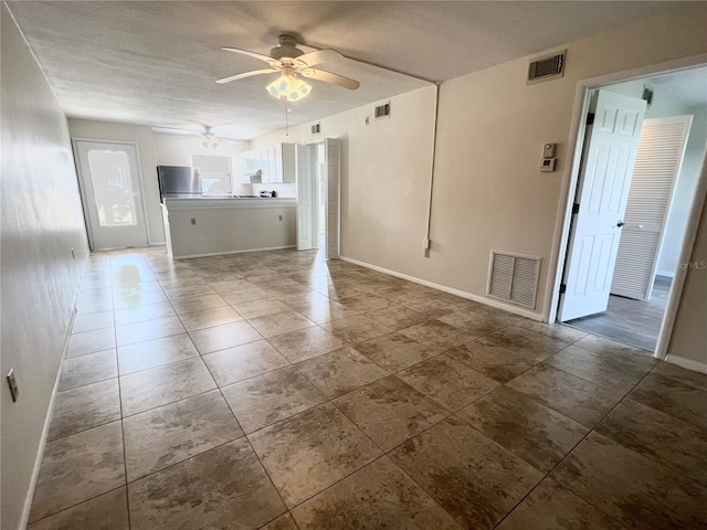 unfurnished living room featuring tile flooring and ceiling fan