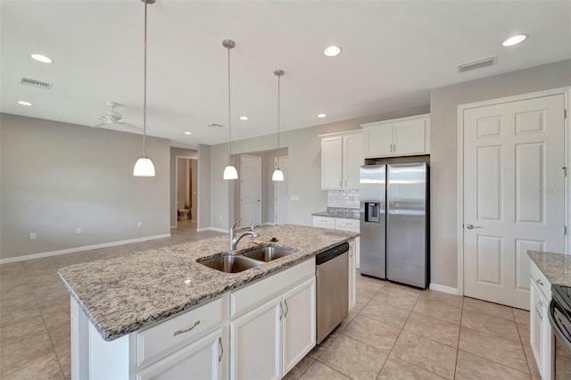 kitchen with stainless steel appliances, decorative light fixtures, sink, a kitchen island with sink, and white cabinetry