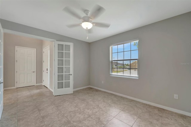 tiled spare room with ceiling fan