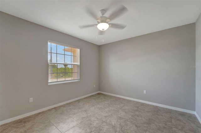 empty room with ceiling fan and light tile flooring