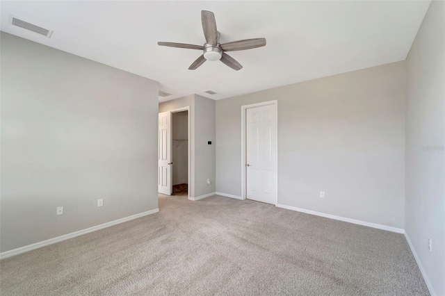 unfurnished bedroom featuring light colored carpet, a closet, and ceiling fan