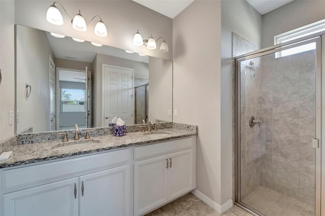 bathroom with a shower with shower door, a healthy amount of sunlight, tile floors, and dual bowl vanity