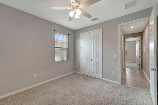 unfurnished bedroom featuring a closet, ceiling fan, and light tile floors