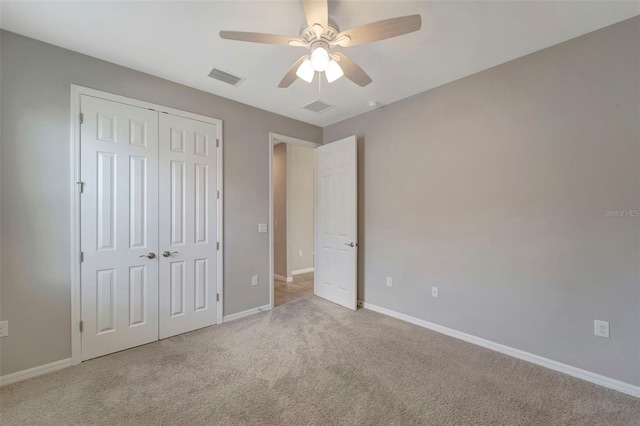 unfurnished bedroom featuring light carpet, a closet, and ceiling fan