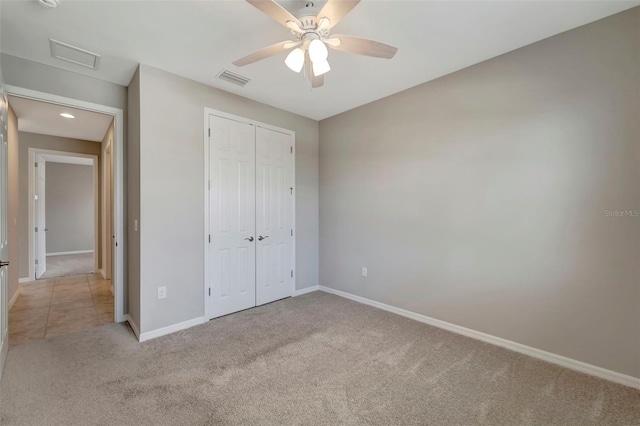 unfurnished bedroom featuring carpet, ceiling fan, and a closet